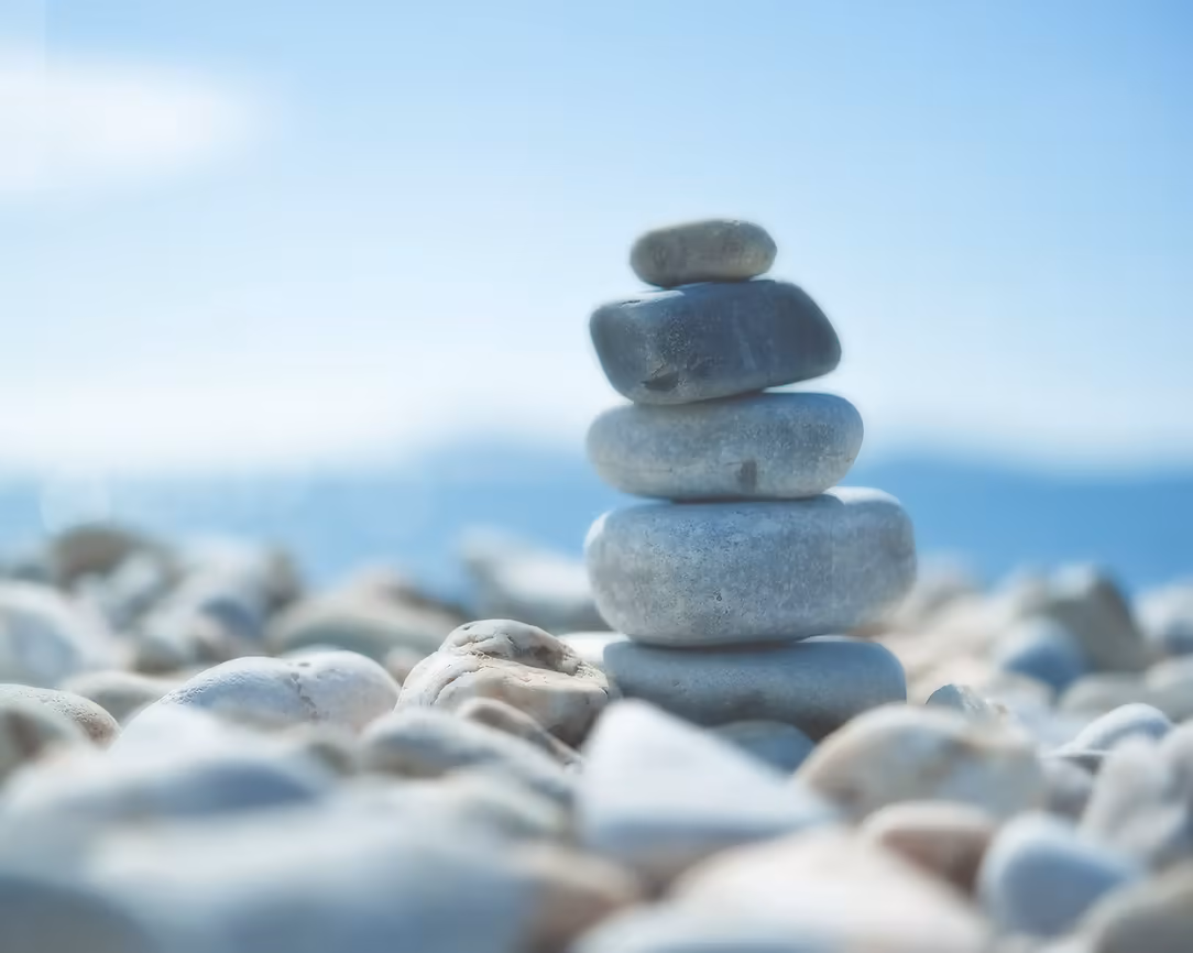 A small stack of smooth stones beside the sea